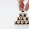 Business man stacking wooden team blocks at table for team management concept or human resource planning